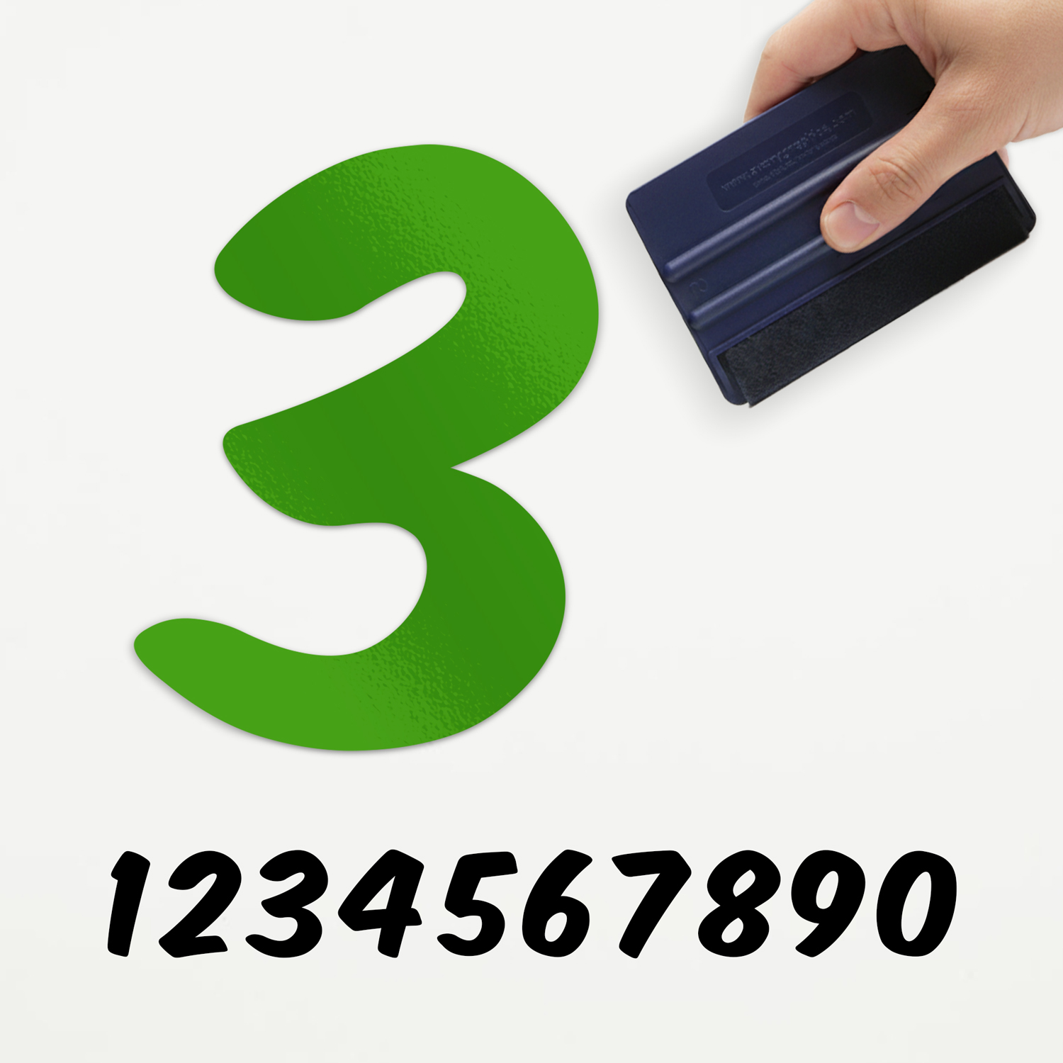 Plakcijfer Los Comic Een voorbeeld van onze losse plakcijfer in type comic. Het is het groene cijfer drie, aangebracht door iemand die een rakel vast heeft.