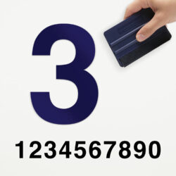 Een voorbeeld van onze losse plakcijfer in type strak. Het is het blauwe cijfer drie, aangebracht door iemand die een rakel vast heeft.