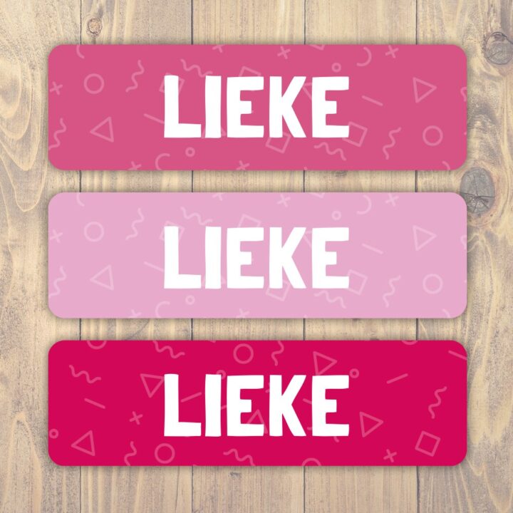 Drie roze naamlabels op een houten achtergrond