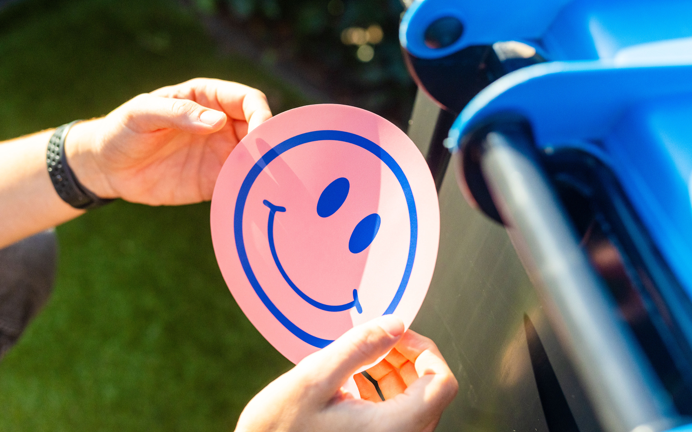 Het opplakken van een vrolijke roze container sticker