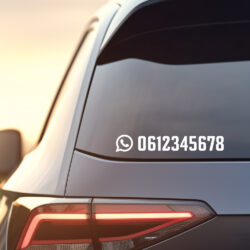 Auto bij ondergaande zon met achter op een duidelijke Whatsapp social sticker.